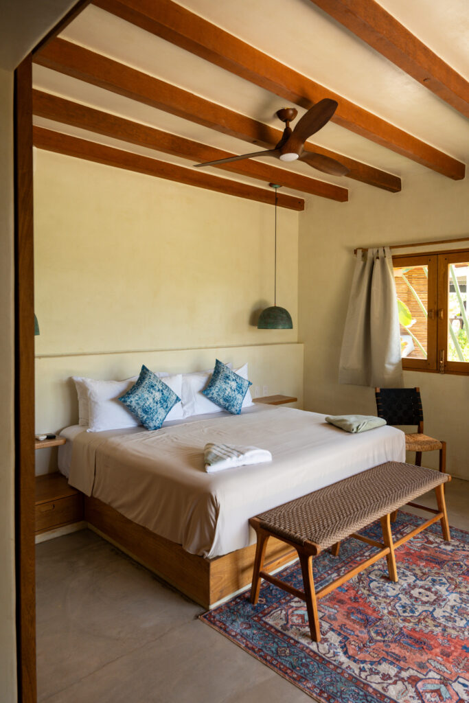 Habitación de lujo en Samas Hotel La Saladita con cama king size, decoración rústica y vigas de madera expuestas.