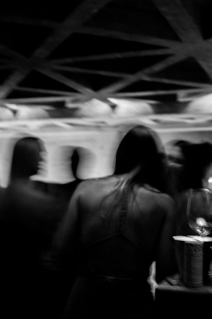 Artistic black and white photo with motion blur of people socializing at night at Samas Hotel, capturing the vibrant ambiance.