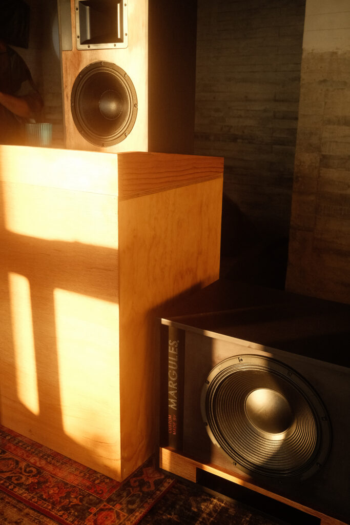 Detail of the high-fidelity Margules brand speakers in a space at Samas Hotel, illuminated by warm sunset light.