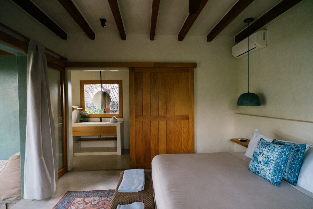 Suite espaciosa con sábanas blancas, decoración artesanal y grandes ventanales en Samas Lasal Hotel.