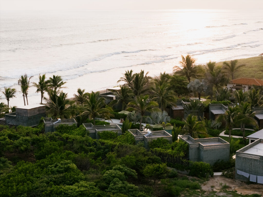 Vista aérea del hotel frente al mar en La Saladita rodeado de palmeras y vegetación tropical.